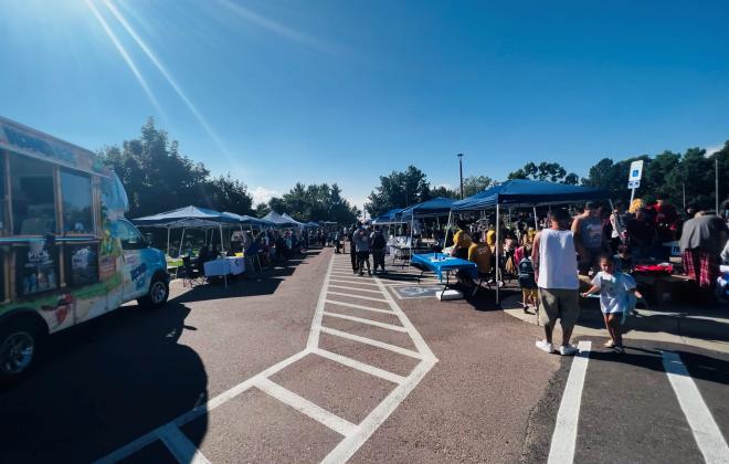 Food trucks, tents and people are set up in the parking lot at Hillside for a food truck event.